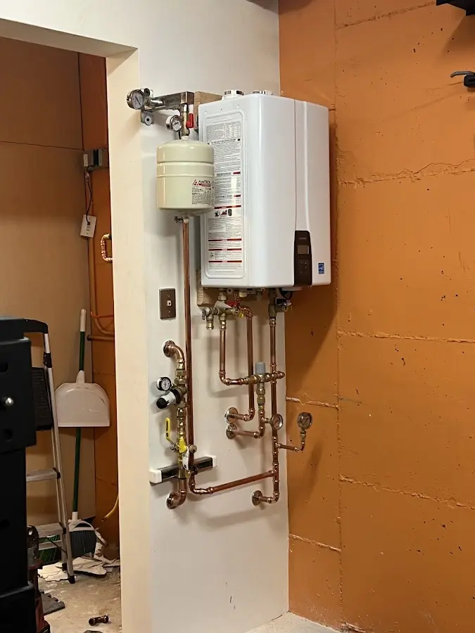 Plumbing technician inspecting water heater connections in Lititz